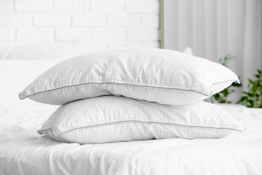 Yatak odasındaki rahat yatakta bir yığın yastık.