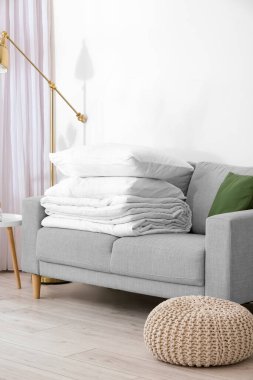 Odadaki kanepede katlanmış battaniye ve yastıklar.