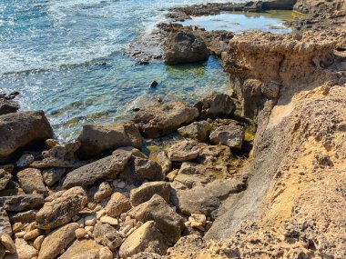 Güneşli bir günde deniz suyuyla kayalık sahil