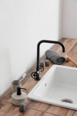 Lavabo, banyo aksesuarları ve ışık duvarının yanındaki masada mumlar.