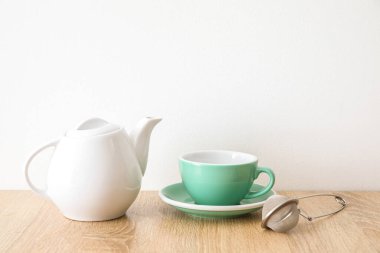 Işık duvarının yanındaki ahşap masada şık bir çay takımı.