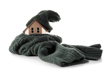 Beyaz arka planda şapkası ve atkısı olan ev modeli. Isıtma kavramı