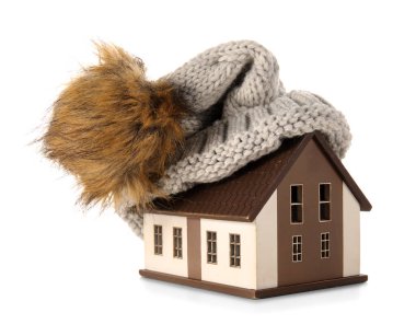 Beyaz arka planda şapkası olan ev modeli. Isıtma kavramı