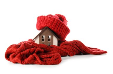 Beyaz arka planda şapkası ve atkısı olan ev modeli. Isıtma kavramı