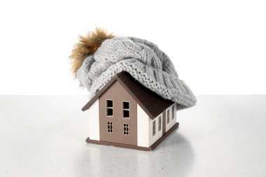 Beyaz arka planda şapkası olan ev modeli. Isıtma kavramı