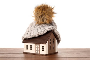 Masada beyaz arka planda duran şapkalı ev modeli. Isıtma kavramı