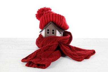 Beyaz arka planda şapka ve eşarplı ev modeli. Isıtma kavramı
