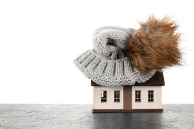 Beyaz arka planda koyu renkli şapkalı ev modeli. Isıtma kavramı