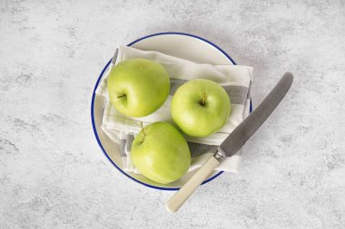 Işık masasında taze yeşil elma tabağı