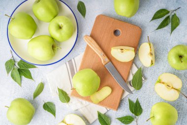 Açık arkaplanda taze yeşil elmalar olan ahşap tahta tahta.