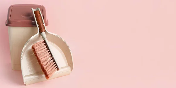 Dustpan, trash bin and brush on pink background with space for text