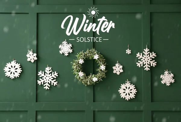 stock image Beautiful snowflakes and Christmas wreath on green wall. Winter Solstice celebration