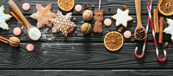 Composition with tasty Christmas cookies and ingredients on dark wooden table