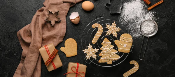 Composition with Christmas cookies, ingredients and gifts on dark background