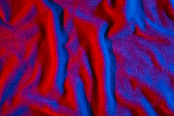 Soft fabric in red and blue neon light as background