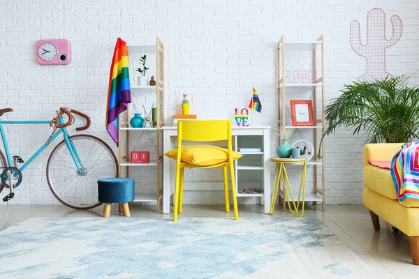 Beyaz tuğla duvarın yanında bisiklet ve gökkuşağı bayraklı işyeri