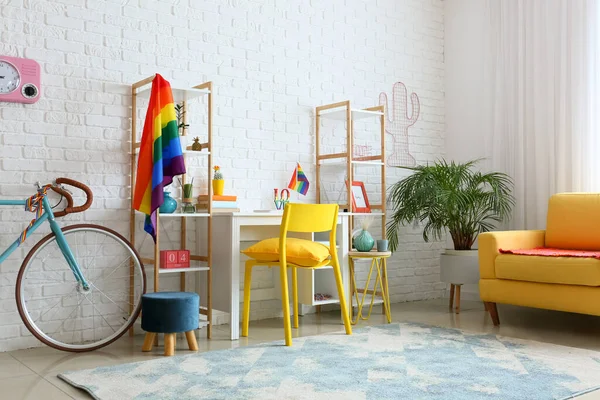 Beyaz tuğla duvarın yanında gökkuşağı bayraklı işyeri