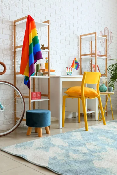 Beyaz tuğla duvarın yanında gökkuşağı bayrakları olan şık bir iş yeri