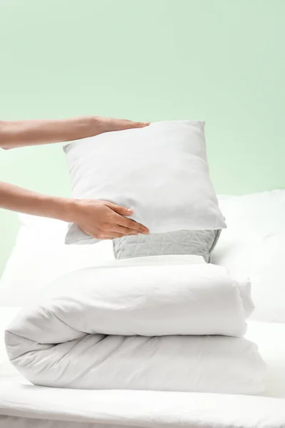 Folded blanket and female hands with pillow, closeup