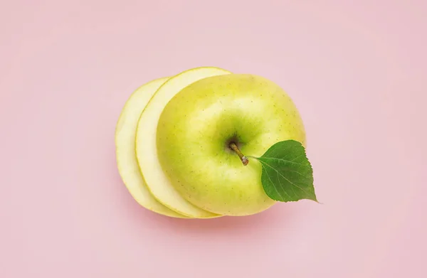 Cut green apple on pink background