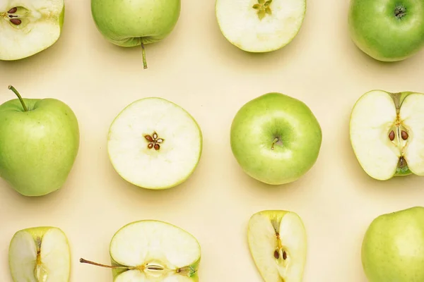 Cut and whole green apples on color background