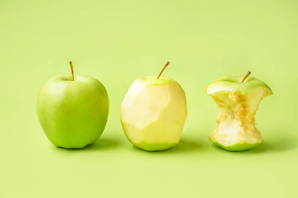 Fresh ripe apples and core on green background