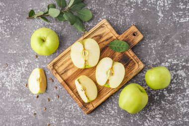 Ahşap tahta tahta, arka planda taze yeşil elmalar.