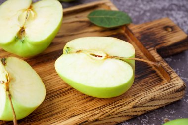 Ahşap tahta tahta, arka planda taze yeşil elmalar, yakın plan.