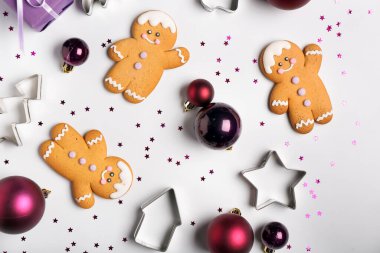 Işık arka planında Noel topları, kurabiyeler ve kesicilerle kompozisyon