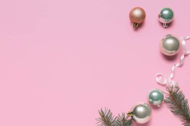 Pembe arka planda Noel baloları ve köknar dalları