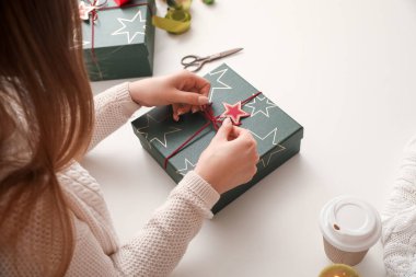 Noel hediye kutusunun yayını bağlayan kadın, yakın plan.