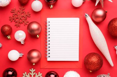 Boş defterli kompozisyon ve kırmızı arka planda güzel Noel süslemeleri