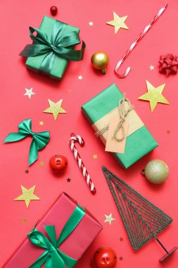 Kırmızı arka planda Noel dekoru olan hediye kutuları