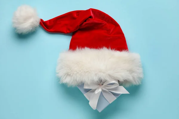 Weihnachtsmütze Und Weihnachtsgeschenk Auf Farbigem Hintergrund — Stockfoto