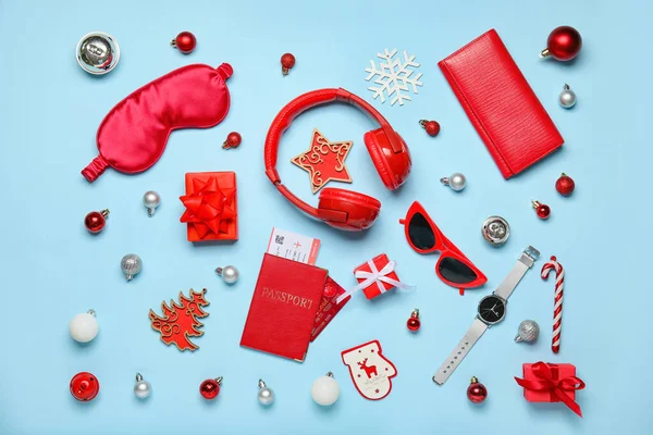 Travel accessories with Christmas decor and gifts on blue background