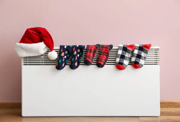 Santa Hat Warm Socks Drying Electric Radiator Pink Wall — Stock Photo, Image