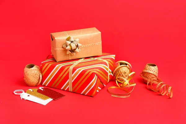Composition with Christmas gift and packing materials on red background