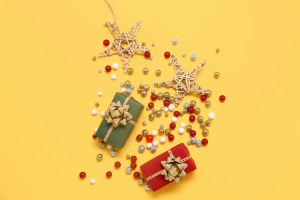 Composition with Christmas gifts and decorations on yellow background