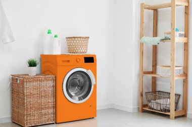 Modern turuncu çamaşır makinesiyle banyo.