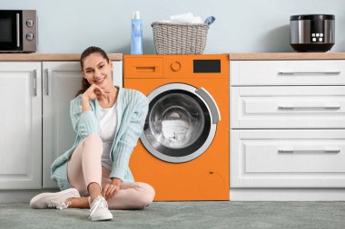 Güzel genç bayan evde çamaşır yıkıyor.