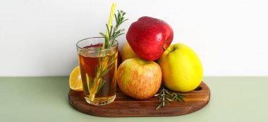 Masada olgun elmalar ve bir bardak taze meyve suyu.