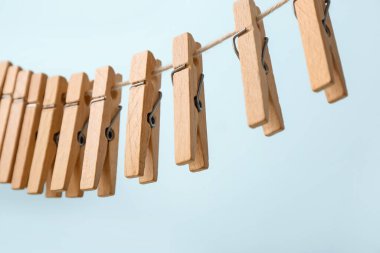 Birçok ahşap mandal mavi arka planda ipte asılı, yakın plan