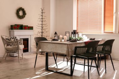 Noel sofrasında çelenk ve yemek odasında yanan mumlar.