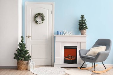 Interior of living room with white door, fireplace and Christmas trees clipart