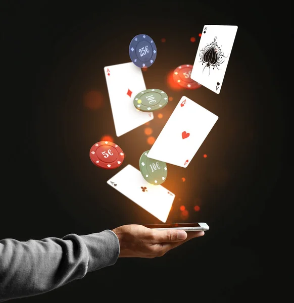 Männliche Hand Mit Mobiltelefon Fliegenden Pokerchips Und Spielkarten Auf Schwarzem — Stockfoto