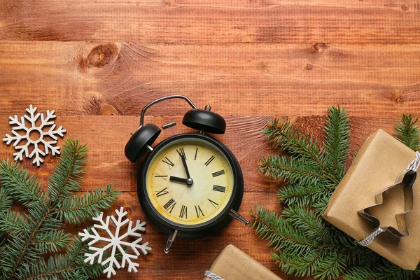 Wecker Mit Weihnachtszweigen Geschenk Und Schneeflocken Auf Holzgrund — Stockfoto