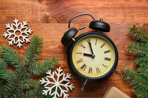 木の背景にクリスマスの枝や雪の結晶と目覚まし時計 — ストック写真