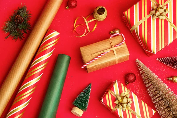 Weihnachtsgeschenke Rollen Geschenkpapier Und Dekorationen Auf Rotem Hintergrund — Stockfoto