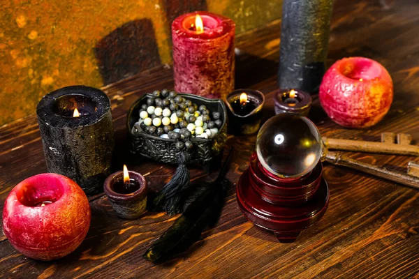 Crystal ball and magic attributes of fortune teller on wooden table