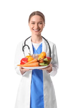 Beyaz arka planda sebze tabağı olan kadın doktor.